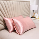 La taie d'oreiller en satin de luxe et confortable rose